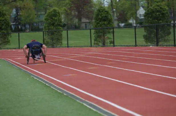 man on wheelchair exercising on running track